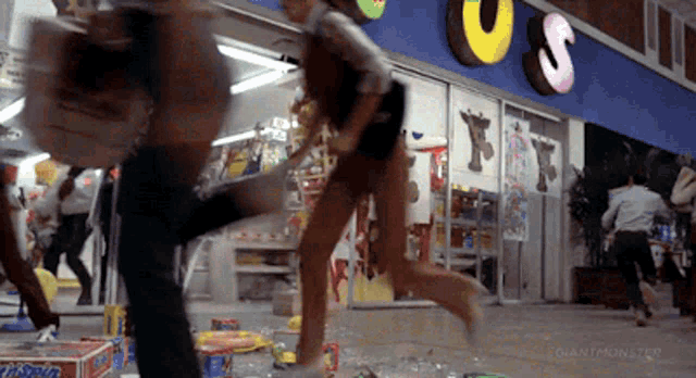 a blurry picture of people running in front of a store that says toys