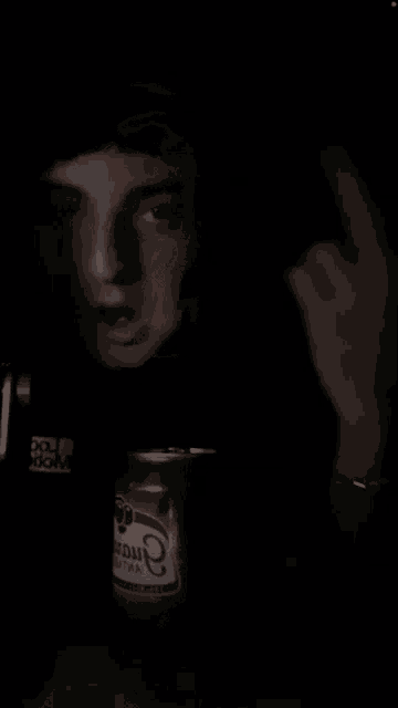 a man in a black shirt holds a can of aruda beer