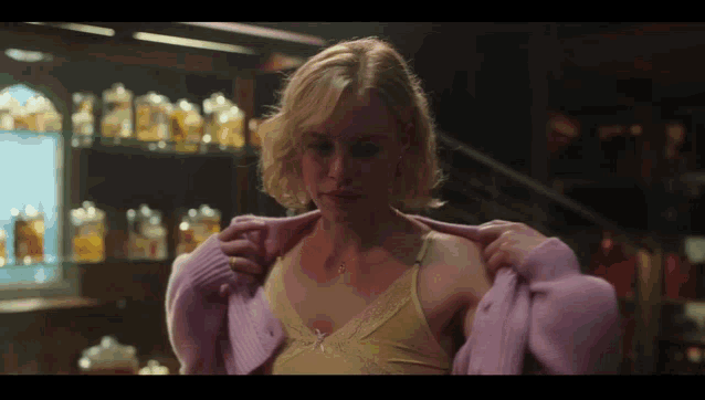 a woman in a yellow bra and a pink cardigan