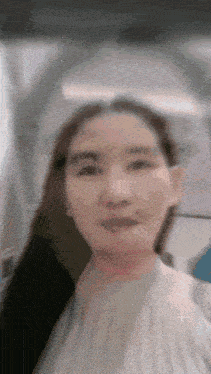 a close up of a woman 's face with a blurred background .