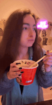 a woman eating a bowl of food with a spoon