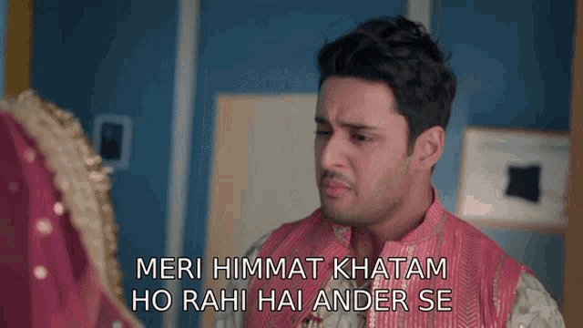 a man in a pink shirt is looking at a woman in a red dress and says meri himmat khatam ho rahi hai ander se