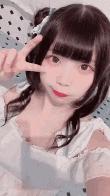 a girl with pigtails is giving the peace sign