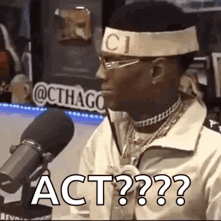a man wearing a headband and glasses is sitting in front of a microphone and saying `` act ? '' .