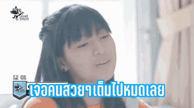a little girl is smiling with a foreign language advertisement in the background