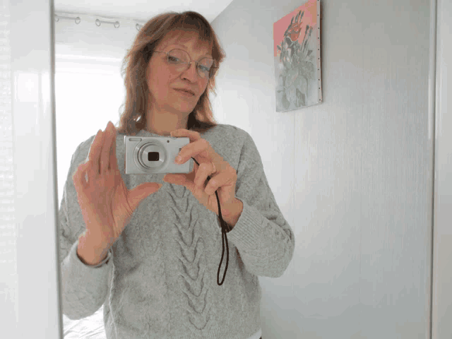 a woman taking a picture of herself with a camera