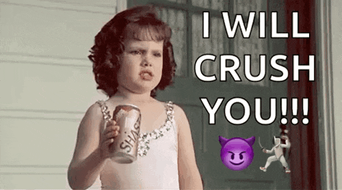 a little girl is holding a can of soda and making a face .
