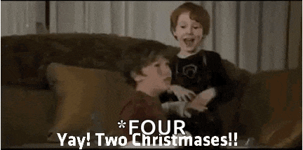 two young boys are sitting on a couch playing with each other and laughing .