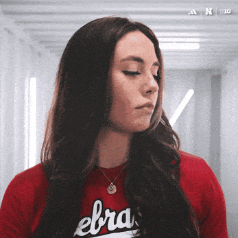 a woman wearing a red zebra shirt looks down