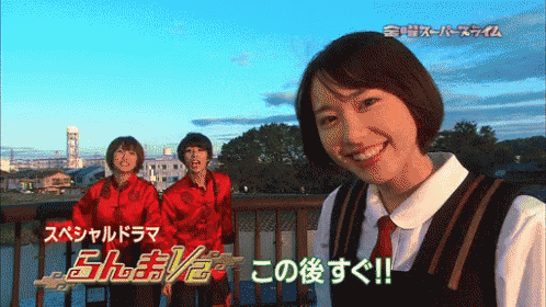 a woman is smiling in front of a sign that says ' スペシャル ドラマ '