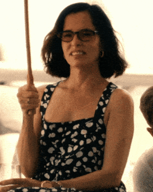 a woman wearing glasses and a black and white polka dot dress