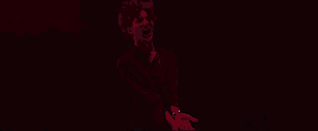 a silhouette of a man in a suit standing in front of a white light .