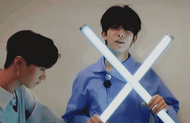 a man in a blue shirt is holding two blue lights