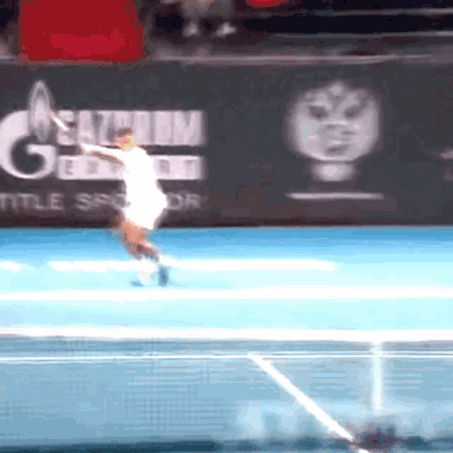 a tennis player is swinging a racket in front of a gazprom sign