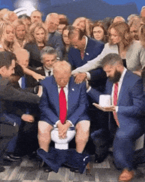 a man in a blue suit and red tie is sitting on a toilet surrounded by people