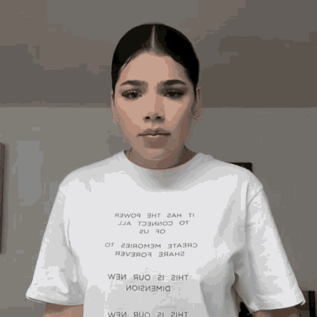 a woman wearing a white t-shirt that says ' я3wo9 3ht 2ah ti ' on it
