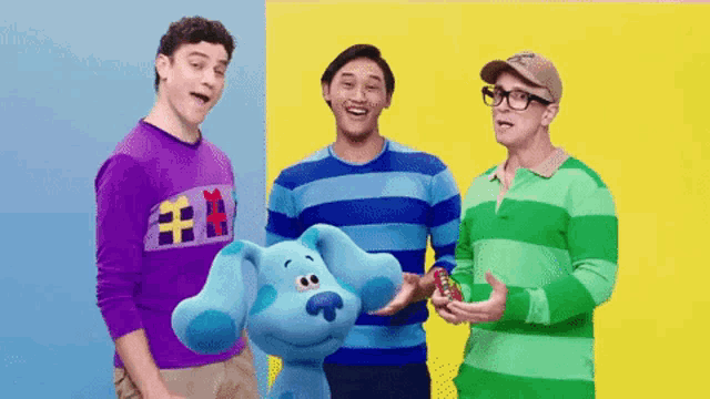 three men are standing next to each other and one of them is wearing a purple shirt with a cat on it