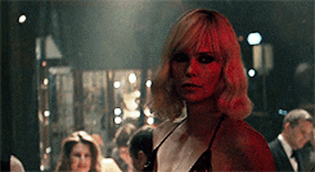 a woman in a red dress is standing in a crowded room