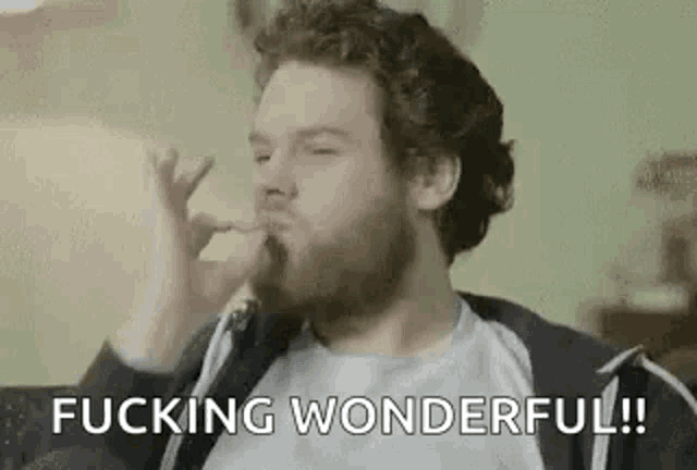 a man with a beard is smoking a cigarette and says `` fucking wonderful ! ''