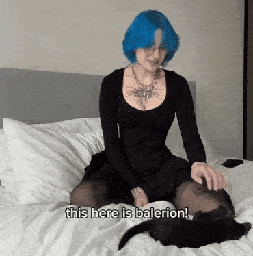 a woman with blue hair sits on a bed with the words " this here is balerion " next to her