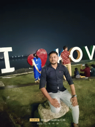 a man kneeling down in front of a sign that says i love