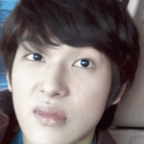 a close up of a person 's face with a slight smirk on their face