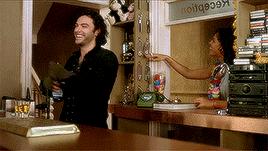 a man and a woman are standing at a counter under a sign that says " noitg909x "
