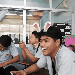 a man wearing bunny ears and a cat face painted on his face