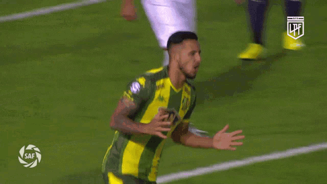 a soccer player wearing a green and yellow jersey with the letters lpf on the front