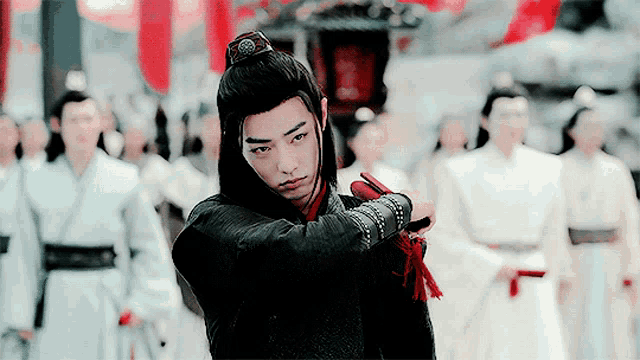a man holding a sword in front of a crowd of men