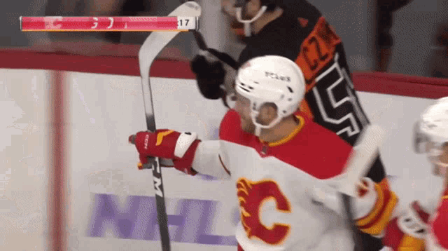 a hockey player wearing a red and white jersey with the letter c on it