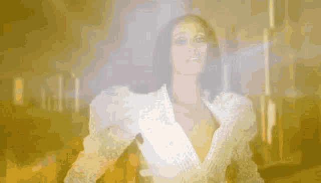 a woman in a white dress is standing in front of a yellow background .