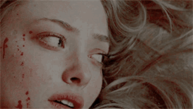 a close up of a woman 's face with tears running down her face