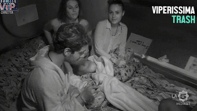 a group of people sitting on a bed with a sign that says " vip "