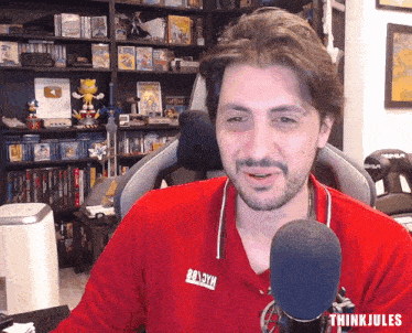 a man wearing a red shirt that says think jules on it
