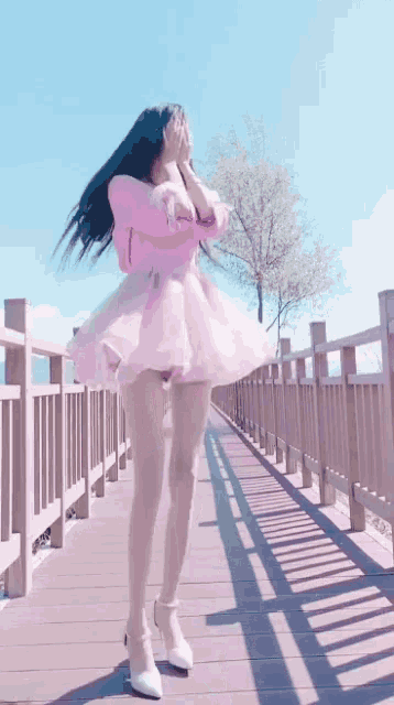 a woman in a pink dress is covering her face