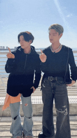 two young men are standing next to each other and giving a peace sign