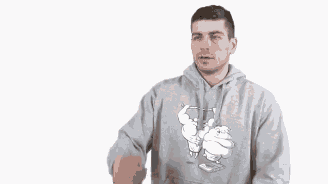 a man wearing a grey hoodie has a cartoon character on it
