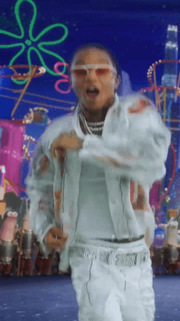 a man wearing sunglasses is dancing in front of a colorful background