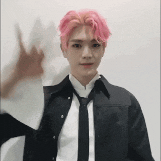 a man with pink hair wearing a black shirt and tie