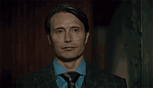 a man in a suit and tie is smiling while looking at the camera .
