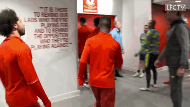 a group of men are standing in front of a wall that says it is there to remind our lads who they