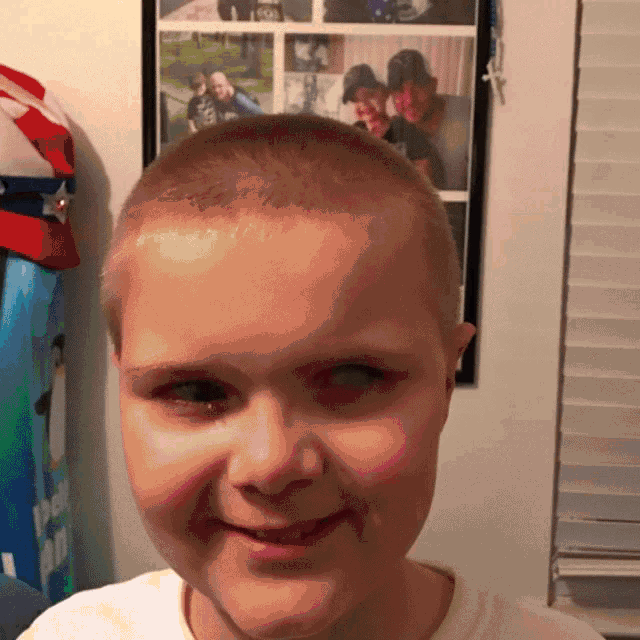 a young boy with a shaved head is smiling in front of a collage of photos