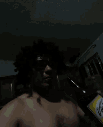 a shirtless man is drinking a bottle of tecate beer