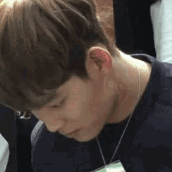 a close up of a person 's face with a name tag around his neck .