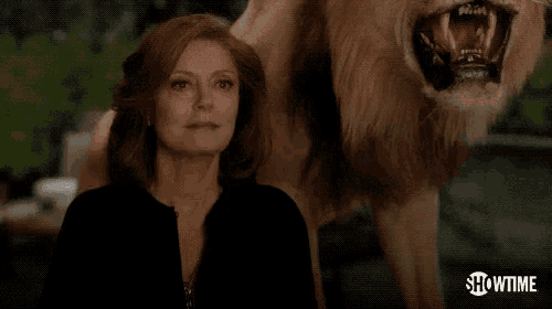 a woman is holding a glass of wine in front of a lion that says cheers