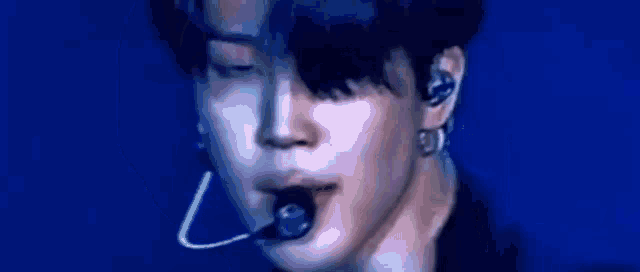 a close up of a person 's face with a microphone in their mouth .