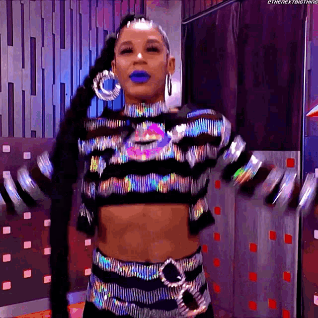 a woman wearing a crop top and pants with a ponytail is dancing with the hashtag #thenextbigthing