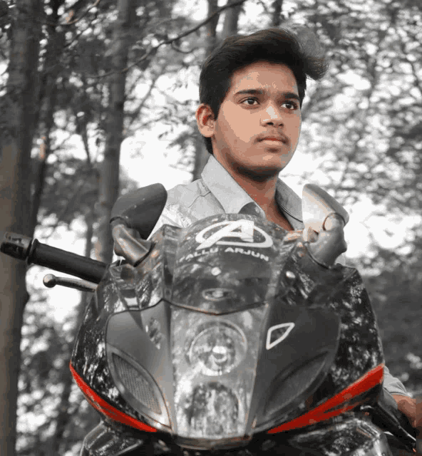 a young man is sitting on a motorcycle with the word arjun on it