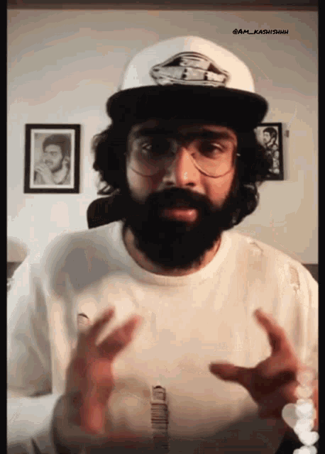 a man with a beard wearing a white hat and glasses